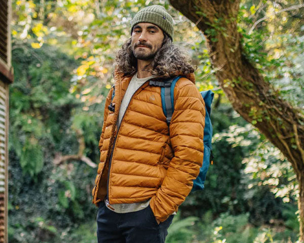 Man wearing orange recycled insulated jacket from outdoor adventure clothing brand Passenger Clothing