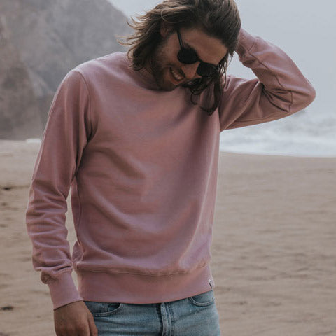 Man wearing pink organic cotton sweatshirt from British sustainable clothing brand Goose Studios