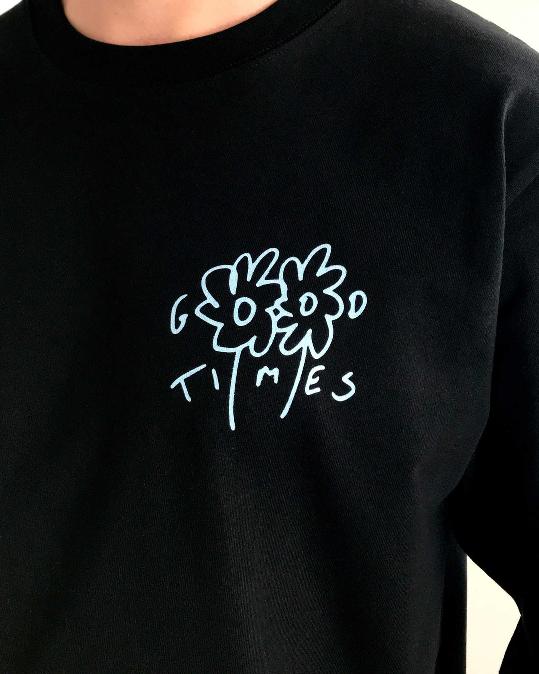Black organic cotton t-shirt made from heavyweight fabric with a light blue floral design and Good Times text on a plain background