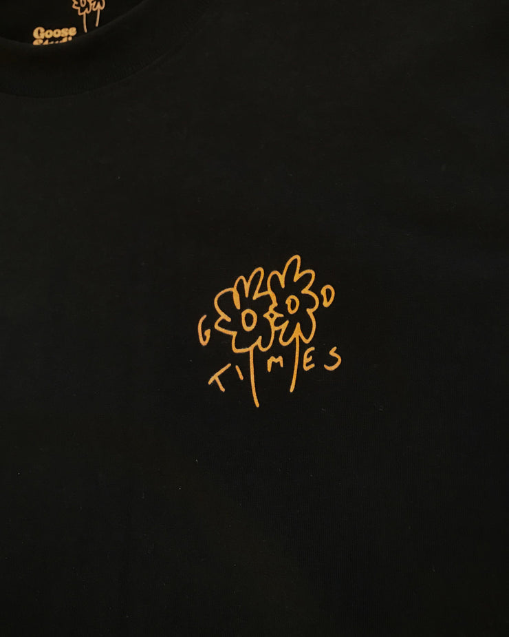 Black t-shirt with an orange hand drawn logo featuring the Goose Studios flowers with the words Good Times incorporated intro the design, printed on a black heavyweight organic cotton t-shirt.