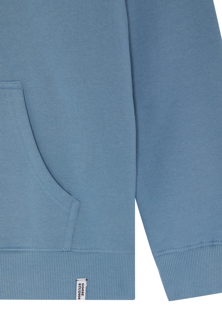 Detail of hoodie pocket on a blue unisex organic cotton hoodie from sustainable clothing brand Goose Studios