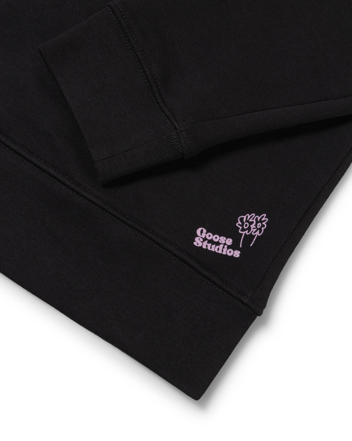 Men's black organic cotton sweatshirt detail shot of the Lilac Label signifying the most sustainable styles Goose Studios make.