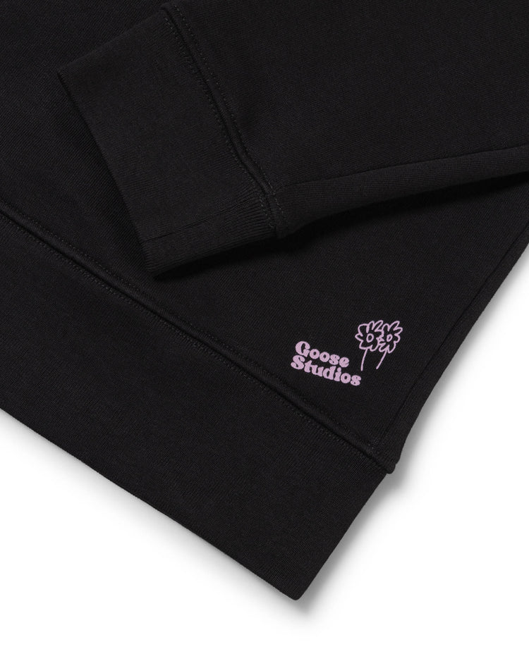 Men's black organic cotton sweatshirt detail shot of the Lilac Label signifying the most sustainable styles Goose Studios make.