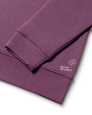 Organic cotton rib cuff detail of a mens organic cotton sweatshirt in Purple, also seen is a lilac logo of Goose Studios signifying a premium product from their catalogue of organic clothing