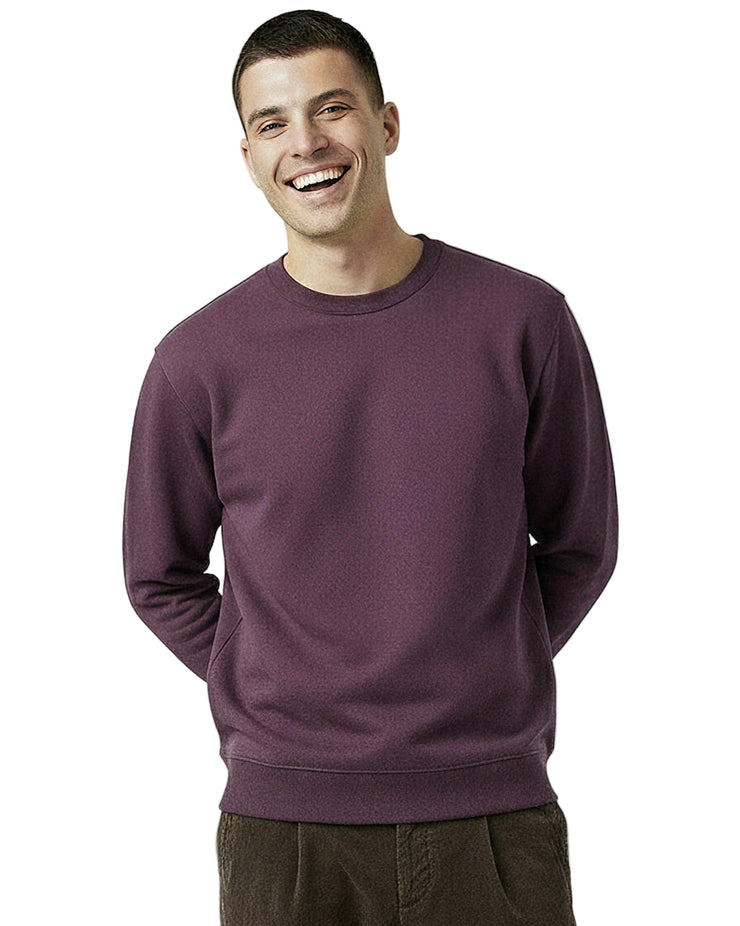 Man wearing an organic cotton purple sweatshirt from Goose Studios and Patta cord trousers on a white background