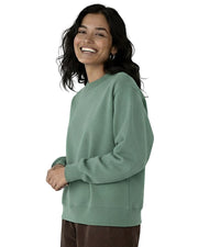 Woman wearing a sage green organic cotton sweatshirt from Goose Studios and brown trousers