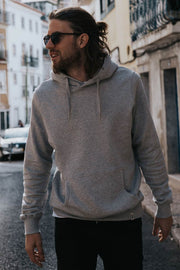 Man wearing grey organic cotton hoodie on the streets of Lisbon wearing sunglasses, hoodie from sustainable clothing brand Goose Studios