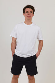 Front of man wearing white workwear organic cotton t shirt with black shorts