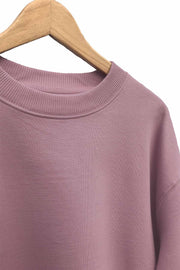 Collar detail of women's organic cotton drop shoulder sweatshirt in dusty pink